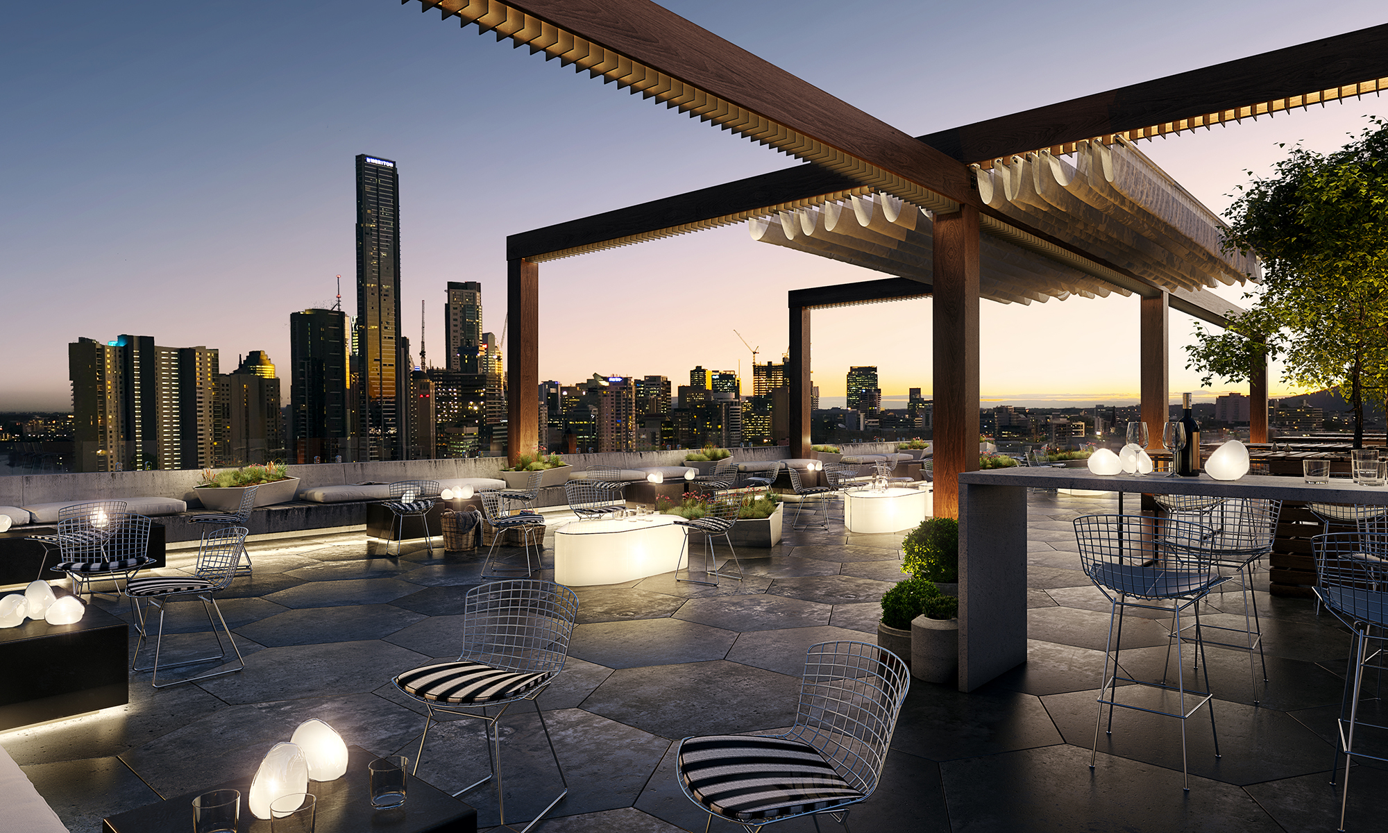 Rooftop outdoor seating area with a stunning hexagonal stone tile flooring and operable awnings, offering a panoramic view of the Brisbane city skyline.