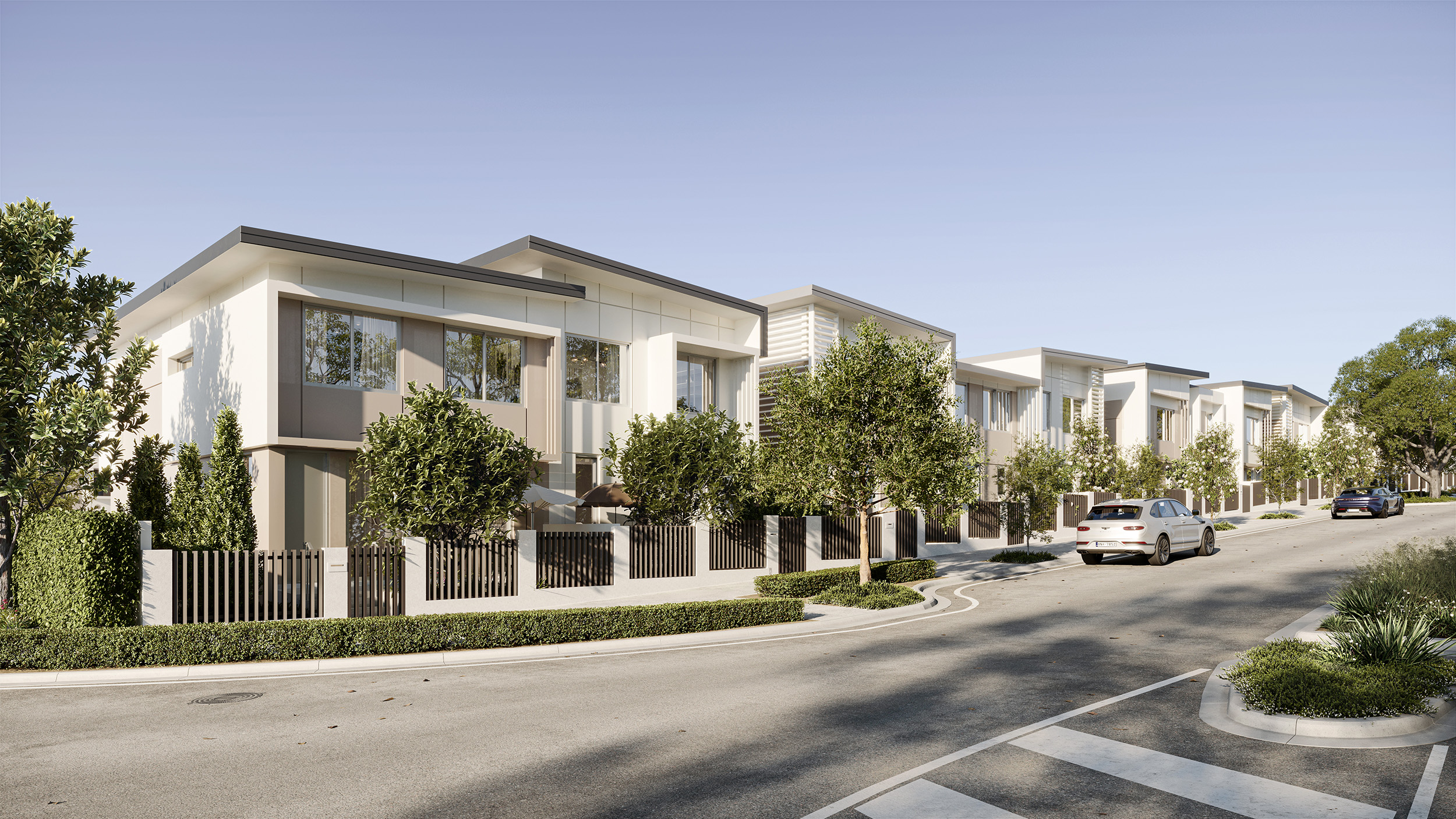 Street view of beautifully designed Armida Residences townhouses with light color palette and privacy fences covered in greenery and battening